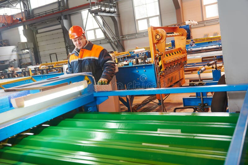 Industrial worker operating metal sheet profiling mechine at manufacturing factory. Industrial worker operating metal sheet profiling mechine at manufacturing factory