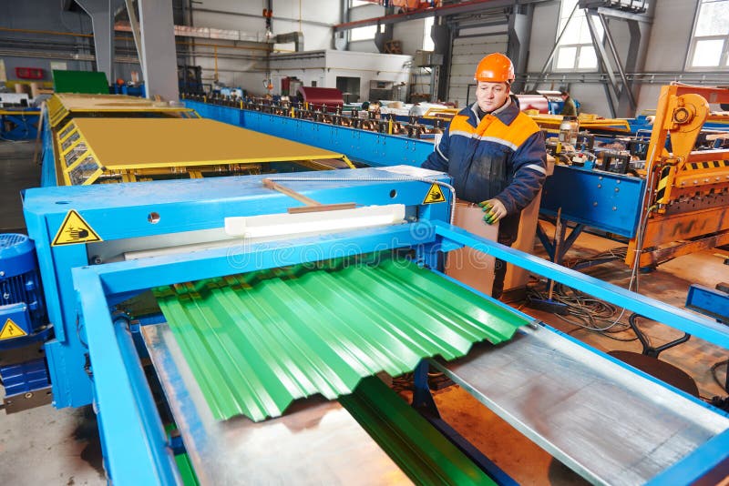 Industrial worker operating metal sheet profiling mechine at manufacturing factory. Industrial worker operating metal sheet profiling mechine at manufacturing factory