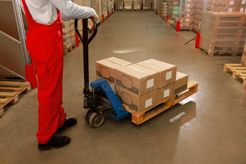 Worker Moving Cardboard Boxes with Manual Forklift in Warehouse, Closeup. Logistics Concept