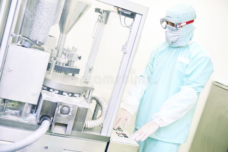 Worker operating tablet or capsule filling machine stock photography Worker operating tablet or capsule filling machine stock photography