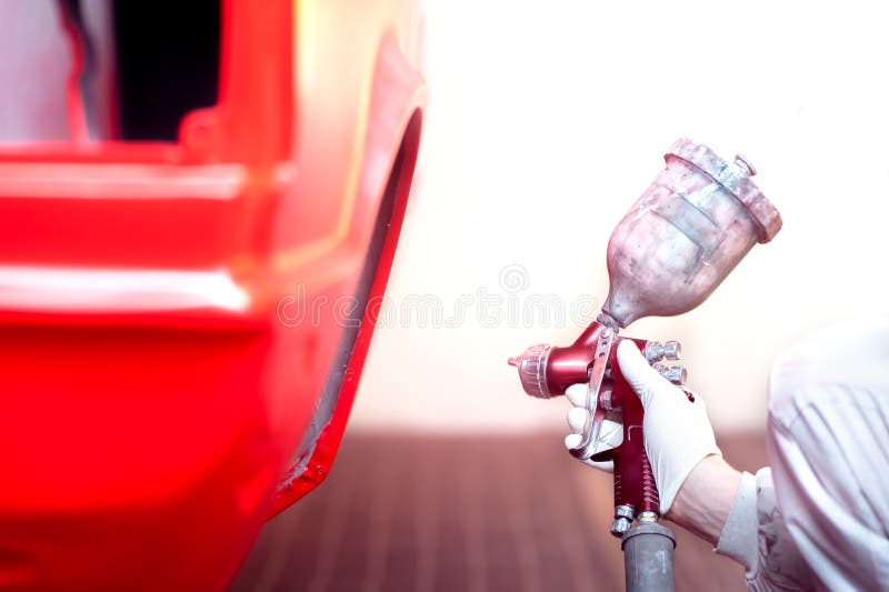 Worker Painting a Red Car in Painting Booth Using Spray Gun Stock Image