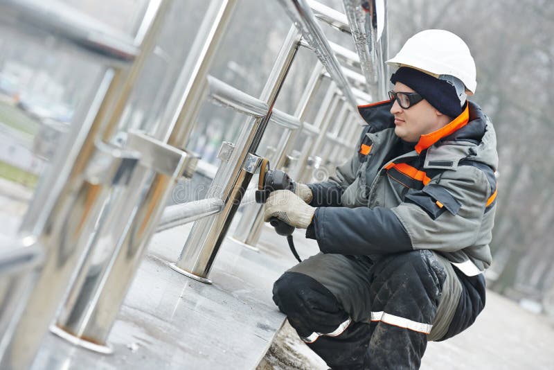Worker polishing metal fence barrier stock images