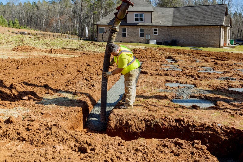 The Worker Pours Concrete for the Foundation of a Building while