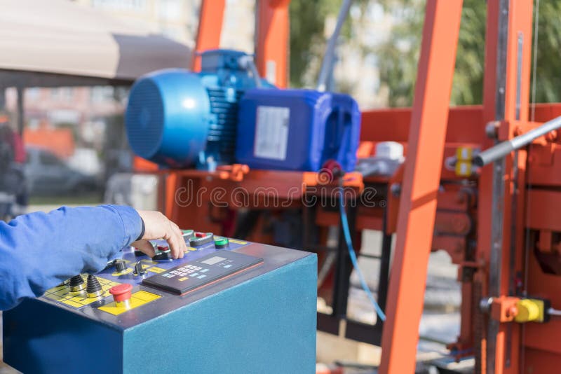 Worker pressing buttons on CNC machine control board in factory. Worker works at a woodworking enterprise. Hand on the machine stock photography