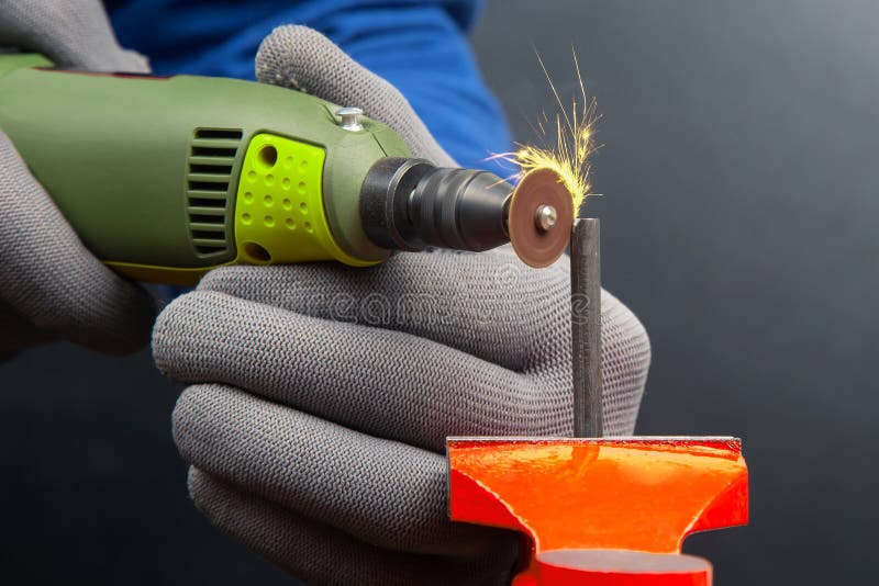 Worker Processes Metal with Engraving Drill Closeup. the Work of the
