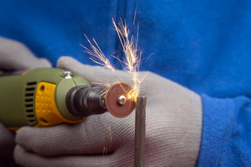 Worker Processes Metal with Engraving Drill Closeup. the Work of the