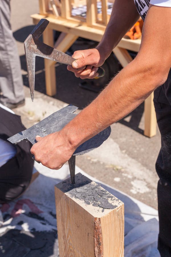 Worker Produces Roofing Slate Using a Slate Hammer. Stock Photo Image