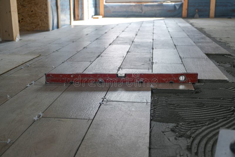The Worker Puts Ceramic Tiles on the Construction Site Stock Photo