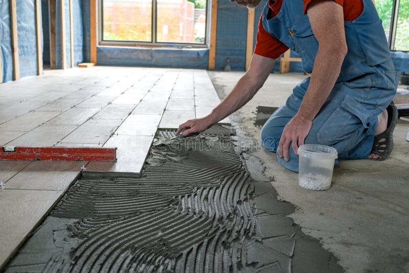 The Worker Puts Ceramic Tiles on the Construction Site Stock Photo
