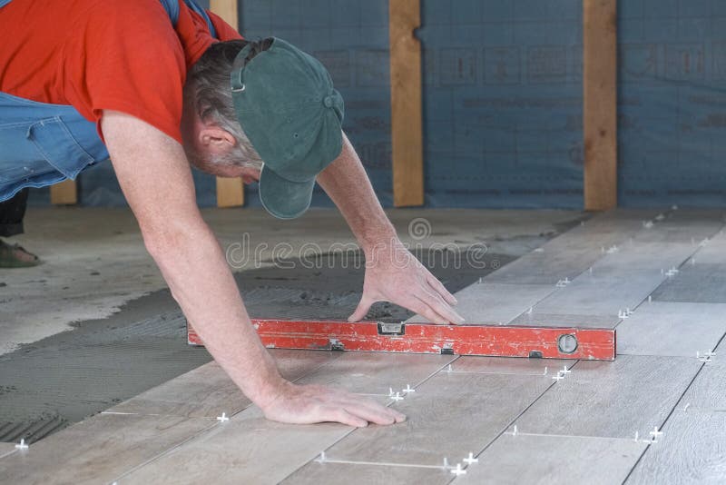 The Worker Puts Ceramic Tiles on the Construction Site Stock Photo