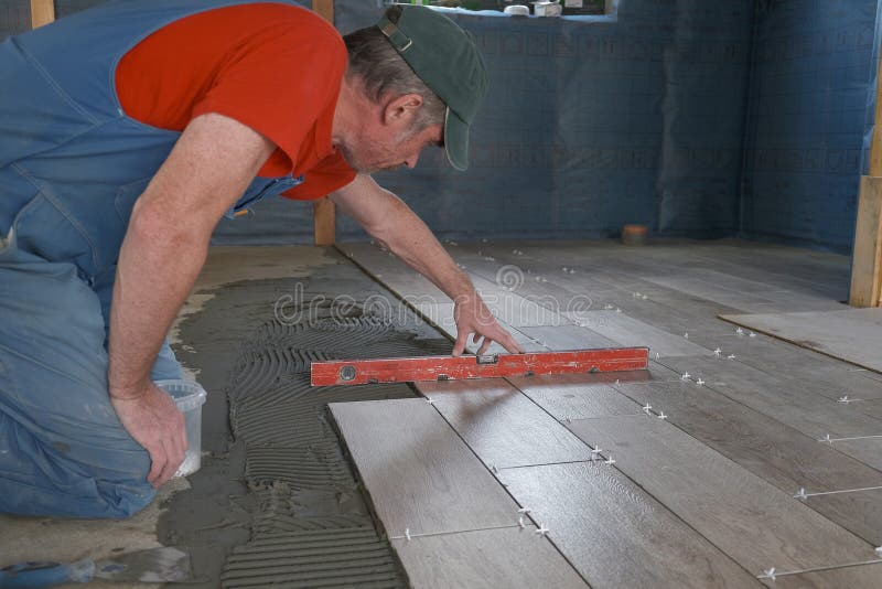The Worker Puts Ceramic Tiles on the Construction Site Stock Image