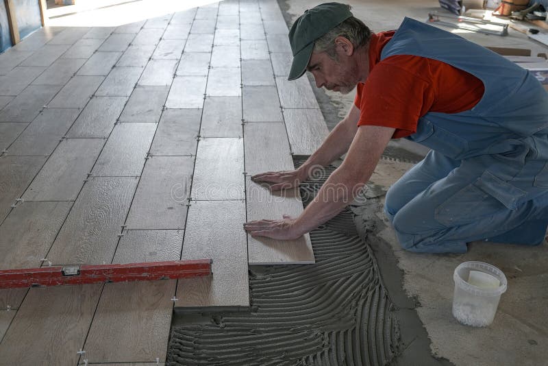 The Worker Puts Ceramic Tiles on the Construction Site Stock Image