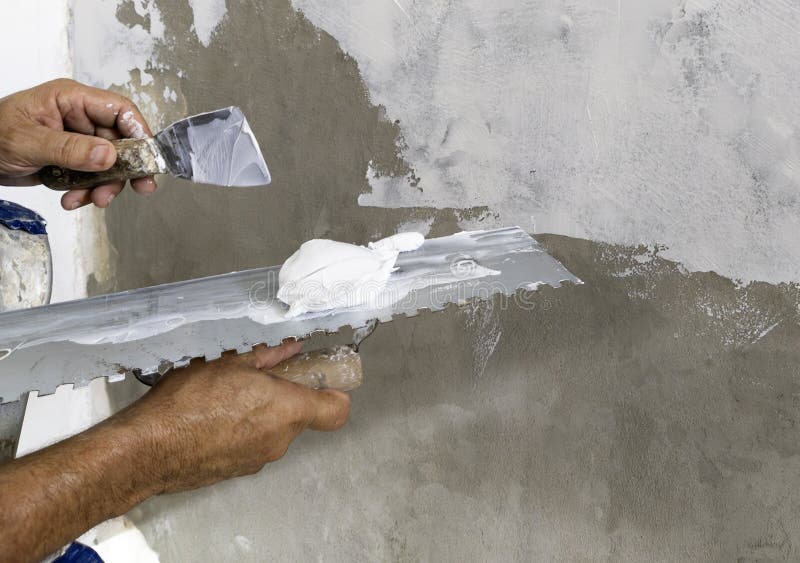 Worker Puts Finishing Layer of Stucco on the Wall Using a Plastering