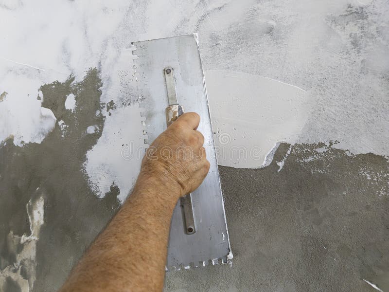 Worker Puts Finishing Layer of Stucco on the Wall Using a Plastering