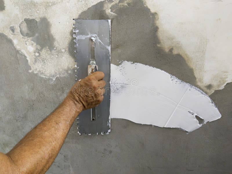 Worker Puts Finishing Layer of Stucco on the Wall Using a Plastering