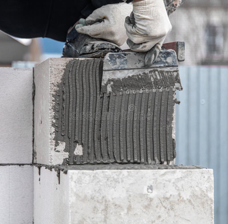 Worker Puts Foam Concrete Bricks into the Wall. Stock Photo Image of builder, construction