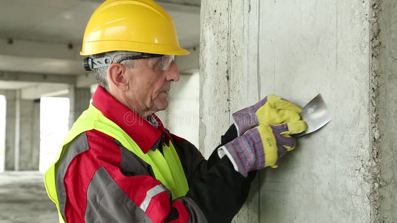 Worker with putty knife on the project site