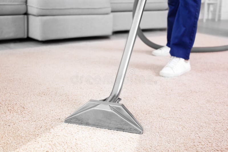 Worker removing dirt from carpet, closeup. Cleaning service