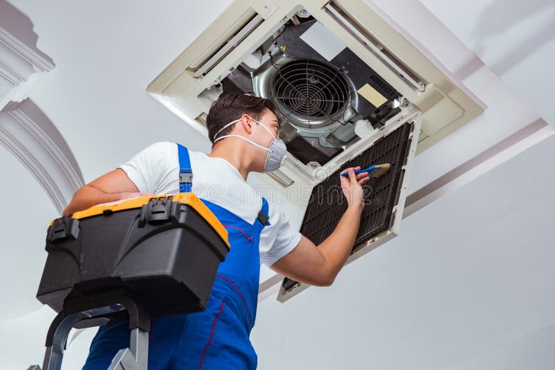 The worker repairing ceiling air conditioning unit