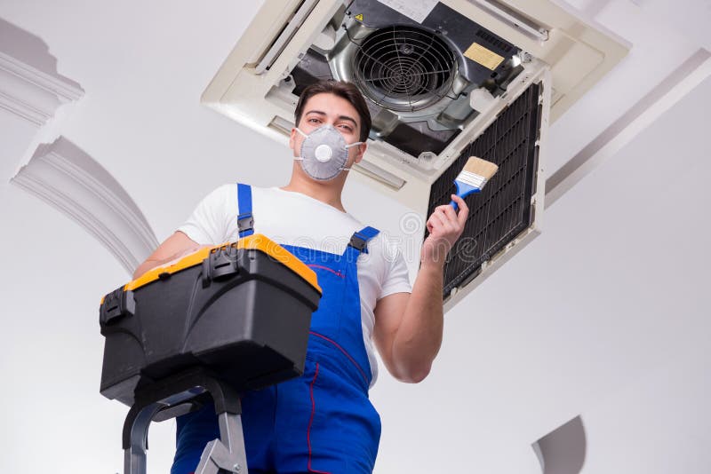 The worker repairing ceiling air conditioning unit