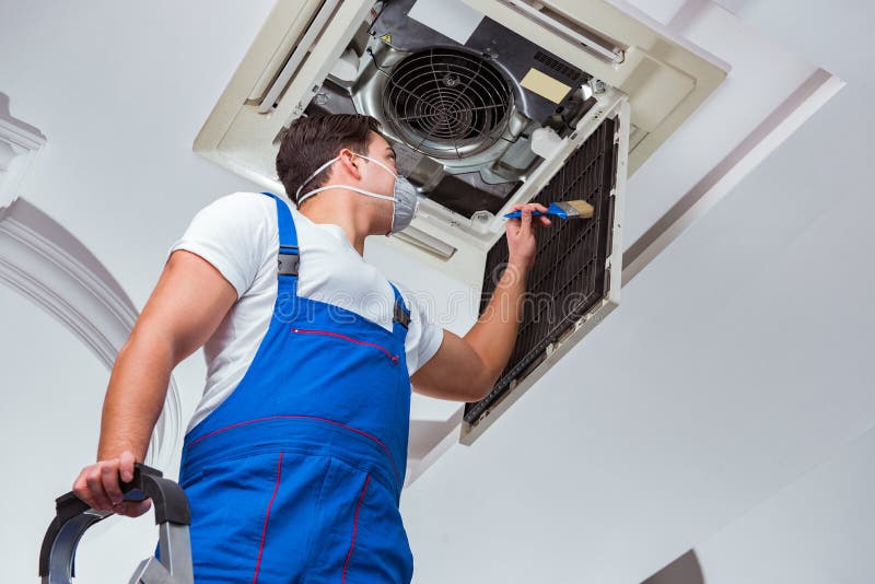 The worker repairing ceiling air conditioning unit