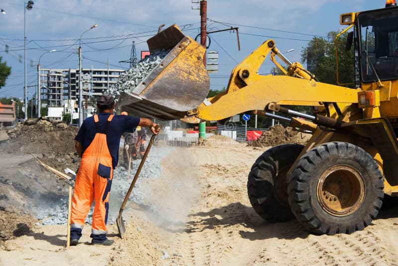 Worker and road loader on construction of road. Track hoe construction excavator stock images, royalty-free photos and pictures