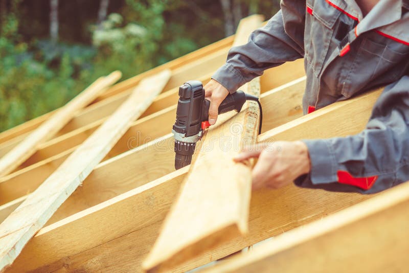 Worker roofer builder working on roof structure on construction site. Worker roofer builder working on roof structure on construction site