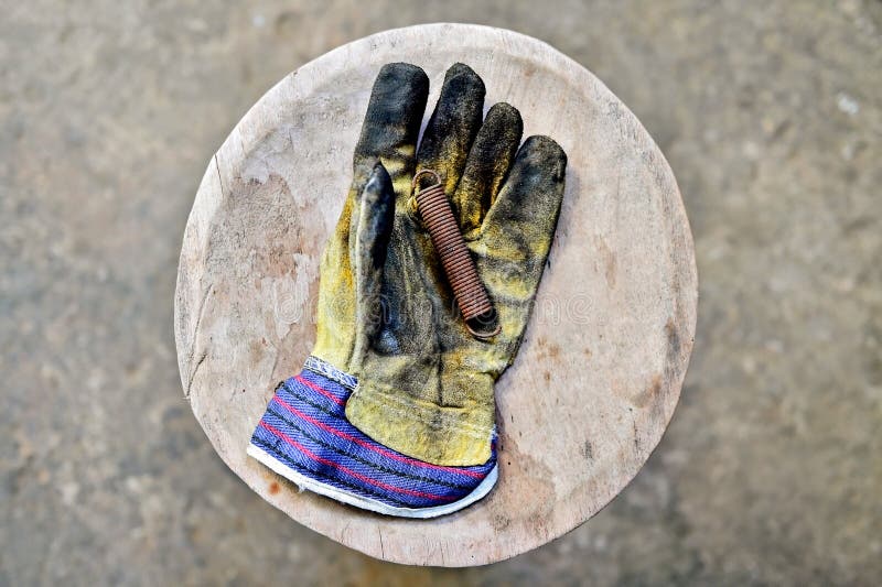 Worker's glove holding rusty spring royalty free stock photo