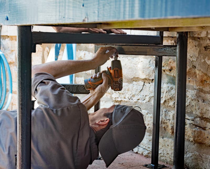 Worker Screwing Step to Underside Mount stock image Worker Screwing Step to Underside Mount stock image