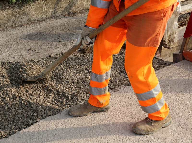 Worker with the Shovel Adjacent at Trench in the Roadwork Stock Photo