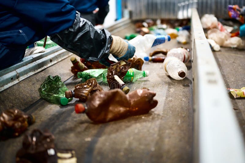 Worker Sorts Trash on Conveyor Belt at Waste Recycling Plant Stock