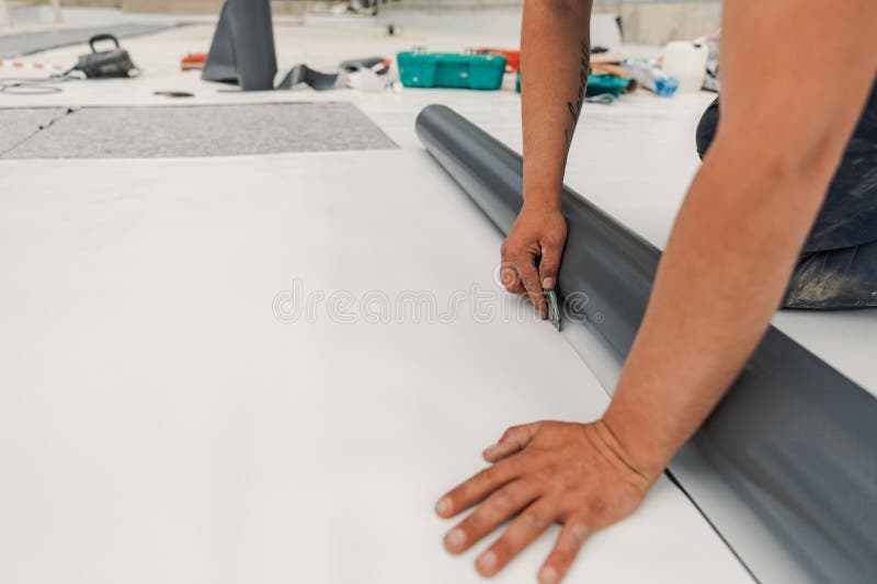 Worker specialized in mounting PVC membranes, TPO in the process of installing a water resistant system stock photography