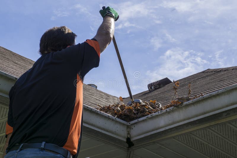 Worker Sweeping Leaves From Roof Valley royalty free stock photo