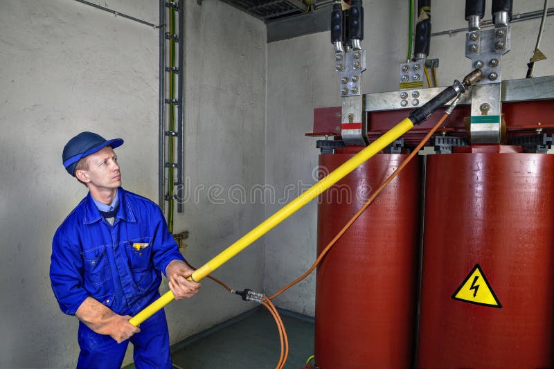Worker uses insulating rod to earth grounding transformer. stock photos Worker uses insulating rod to earth grounding transformer. stock photos