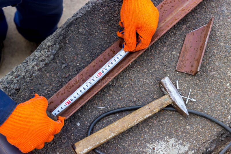 Worker Uses Measuring Tape for Work. Measures a Metal Corner before