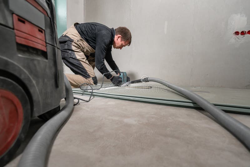 Worker is Using a Building Tool, the Milling Tools and a Vacuum Cleaner