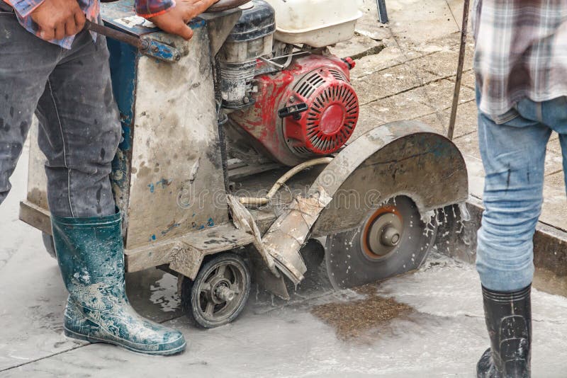 Worker Using Diamond Saw Blade Machine Cutting Concrete Road at