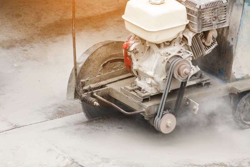 Worker Using Diamond Saw Blade Machine Cutting Concrete Road at Construction Site Stock Photo