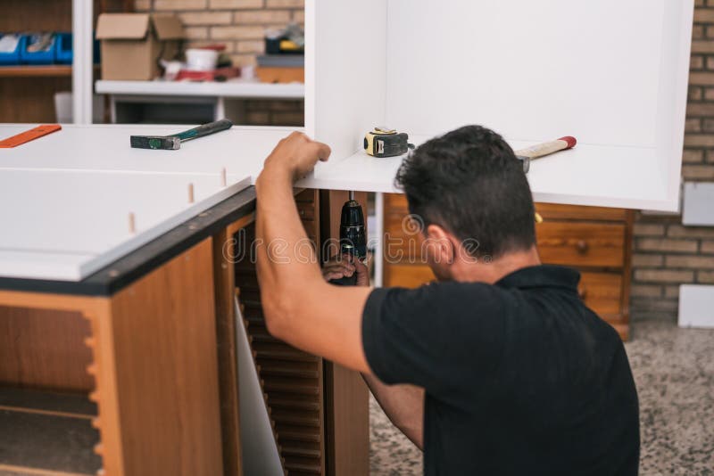 Worker Using a Drill To Build a Kitchen Furniture Stock Image Image
