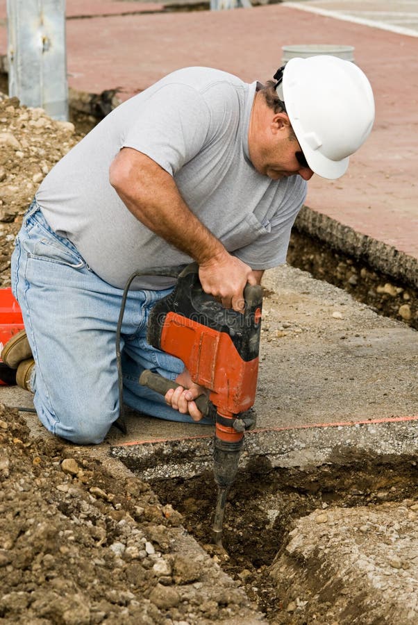 Bauarbeiter mit einem hammer Meißel oder bohren, Graben durch die felsigen Boden.