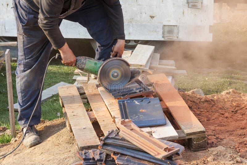 Worker Using a Hand Circular Saw To Cut Rooftile Stock Photo Image