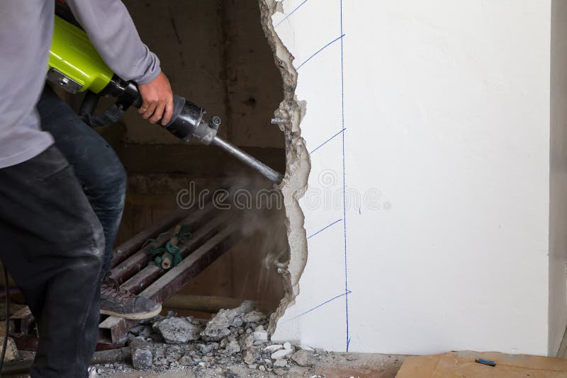 Worker Using a Jackhammer To Drill into Wall. Stock Image Image of