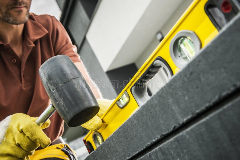 Worker Using Level Tool to Align Construction Materials Outdoors royalty free stock image