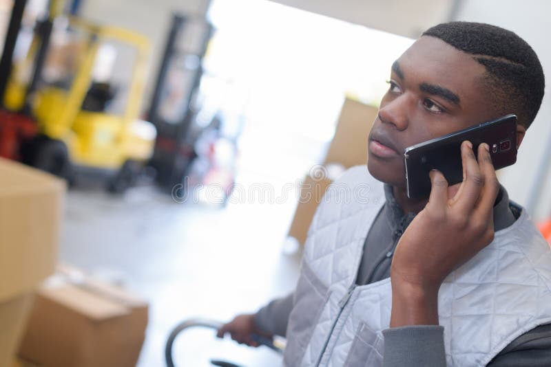 worker-in-logistics-warehouse-using-forklift-checking-list-stock-image