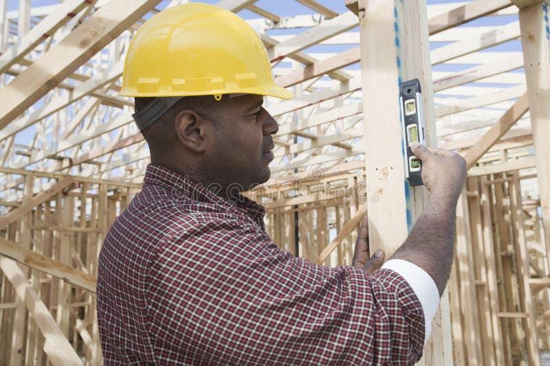 Male worker using spirit level at construction site. Male worker using spirit level at construction site