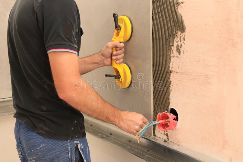 Worker Using Suction Plate for Tile Installation Indoors, Closeup Stock