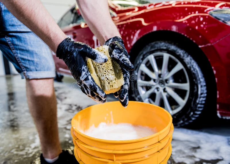 Premium Photo  Worker washing car with active foam on a car wash.