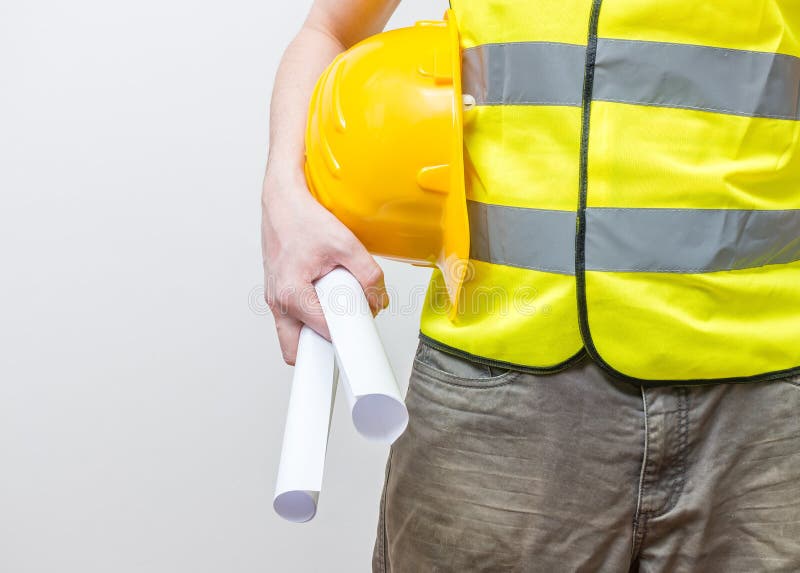 Worker with yellow helmet holds blueprints stock images