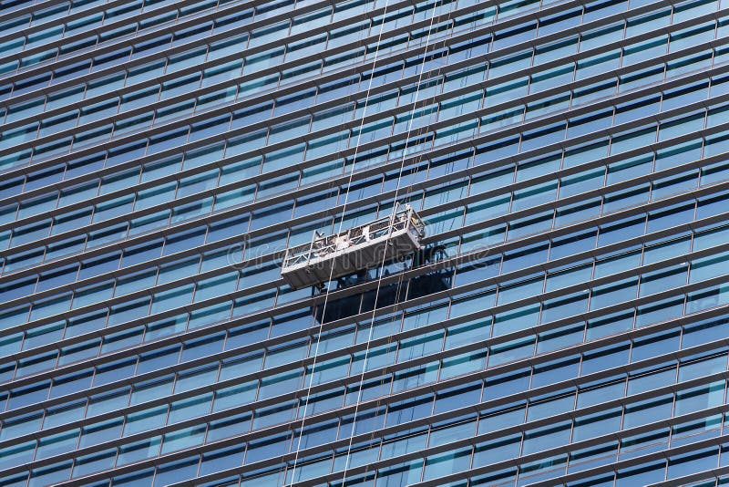 Workers cleaning windows outside building.