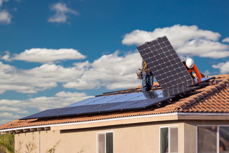 Workers Installing Solar Panels on House Roof stock photography